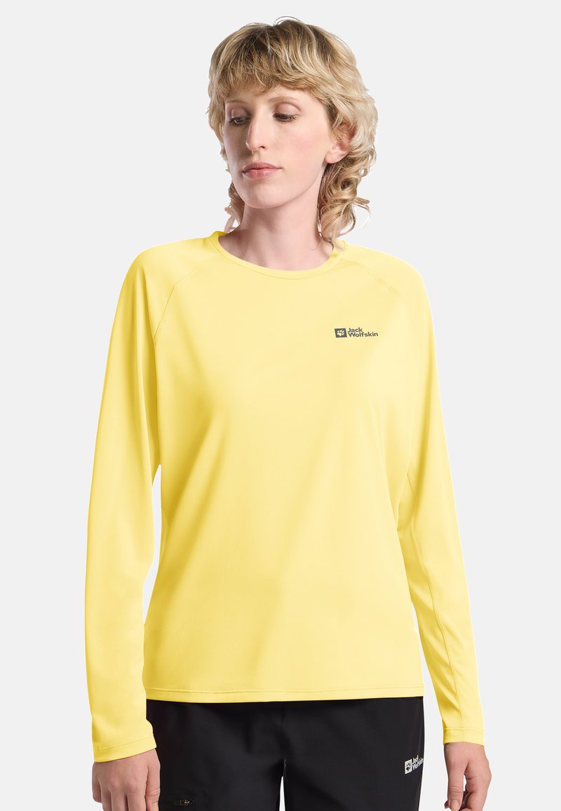 Langärmliges, gelbes technisches Shirt mit Rundhalsausschnitt und Logo-Akzenten auf der Brust. Glatte Textur und leichtes Material.