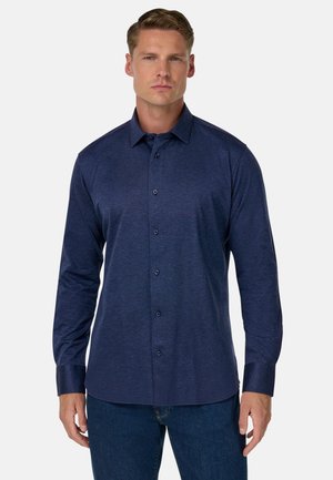 Langarmshirt in donker marineblauw, gemaakt van textuurstof, met een knopenlijst aan de voorkant en een gestructureerde kraag.