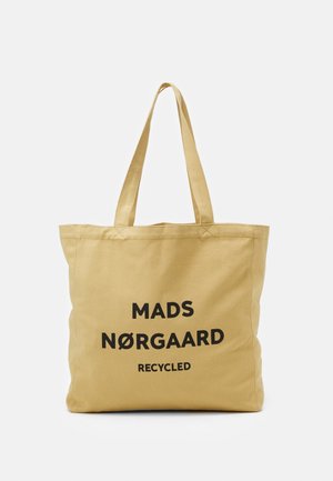 Beżowa torba na ramię z płótna z dwoma uchwytami, z czarnym napisem „MADS NØRGAARD RECYCLED” wyśrodkowanym z przodu.