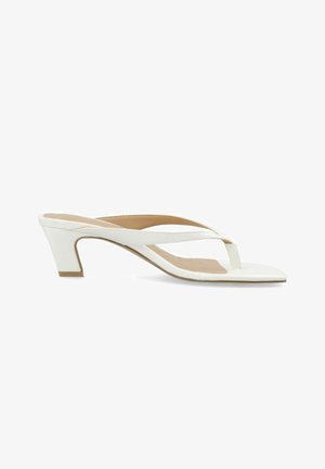 Weiße Leder-Sandalette mit offenen Zehen, Zehenriemen und einem niedrigen, zulaufenden Blockabsatz, von der Seite vor weißem Hintergrund gezeigt.