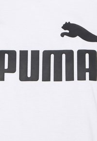 Balta medvilninė marškinėliai su ryškiu juodu "PUMA" tekstu ir juodu šokuojančiu katinu virš žodžio. Paprastas, švarus dizainas ir klasikinis prisitaikymas.