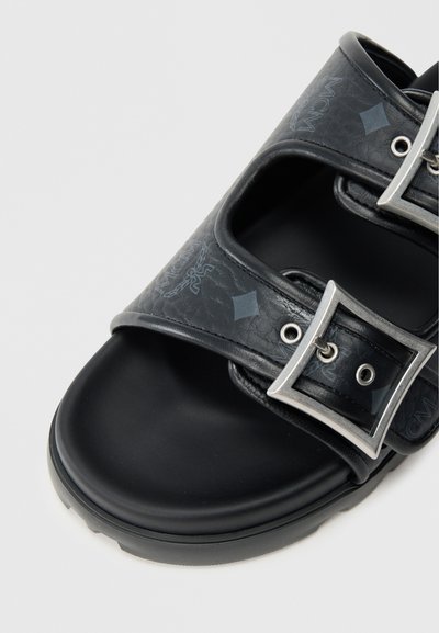 Sorte sandaler med præget lædertekstur, der har to justerbare sølvspænder og en tyk sort gummisål.