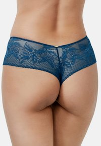 Marineblauwe kant boyshorts met bloemenborduurwerk, doorzichtige mesh en golvende randen met een kleine gouden accent aan de achterkant.