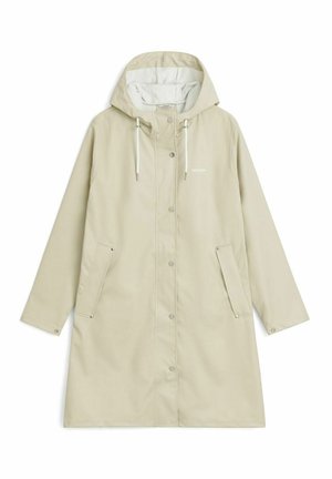 Light beige raincoat with a hood, snap buttons, two side pockets, and drawstring details. Features a smooth, waterproof texture and brand logo.