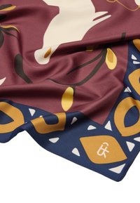 Jedwabny szalik z bordowym tłem zdobionym abstrakcyjnymi żółtymi i białymi kształtami, obramowany granatową sekcją z geometrycznymi wzorami i brandingiem.