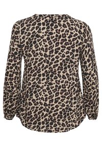 Blouse à manches longues en tissu beige avec imprimé léopard noir et rose, dotée d'un col rond et de poignets élastiques.