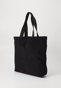 Μαύρη τσάντα ώμου από κοτλέ με δύο υφασμάτινες χειρολαβές, ορθογώνιο σχήμα, υφή επιφάνειας, και ραμμένο άκρο στην κορυφή. Απλός και λειτουργικός σχεδιασμός.