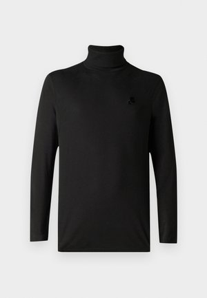 Melna garo piedurkņu turtlenecks krekls ar nelielu, diskrētu logotipu augšējā kreisajā krūtīs, izlikts uz vienkārša baltā fona.