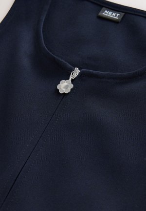 Mornarsko modro oblačilo z okroglo izrezom in zadrgo s srebrnim cvetličnim potegom. Tkanina ima teksturiran, trden videz.