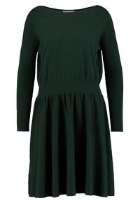 Mörkgrön klänning med rund halsringning, långa ärmar och en figursydd midja som flödar ut i en full kjol. Mjuk, texturerad tyg.