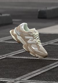 Beige och ljusgröna sneakers med nät- och mockamaterial, med reflexdetaljer, intrikat sula och snören.