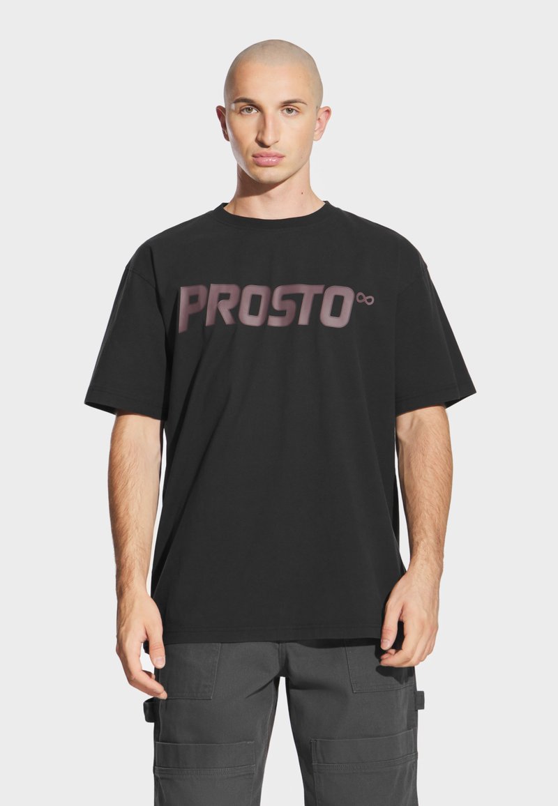 Czarna bawełniana koszulka z krótkim rękawem z logo "PROSTO" na przodzie i tyle w różnych odcieniach, okrągłym dekoltem i luźnym krojem.