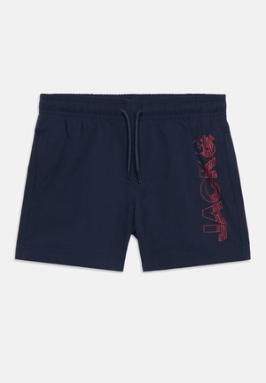 Pantaloni scurți de baie bleumarin cu talie elastică, șnur de strângere, buzunare laterale și design text roșu aliniat vertical pe piciorul drept.