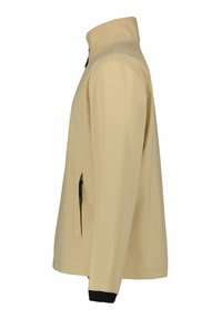 Beige softshell-jacka med ståkrage, dragkedjefickor på sidan och svarta ärmslut. Slät textur och strömlinjeformat design.