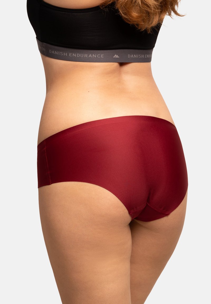 Shorts bordeaux senza cuciture con una texture liscia e una vita media, caratterizzati da un design minimalista senza cuciture o loghi visibili.