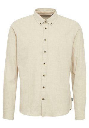 Beige langermet skjorte laget av teksturert stoff, med krage med knapper og mørke knapper foran.