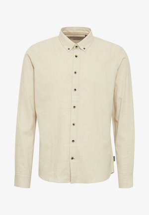 Beige langermet skjorte laget av teksturert stoff, med krage med knapper og mørke knapper foran.