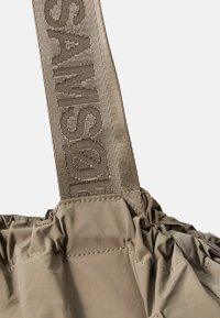 Khaki håndveske med rynkete stoff, en tykk vevd stropp med "SAMSONITE" preget, og glatt tekstur med synlige sømdetaljer.
