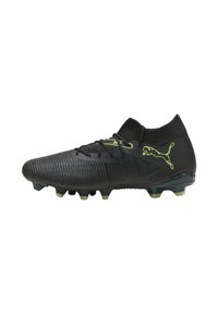 Botín de fútbol negro con parte superior texturizada, cuello de punto y acentos en verde lima. Cuenta con una suela con tacos para tracción en superficies de hierba.