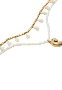 Naszyjnik z koralików z złotymi akcentami, białymi kwadratowymi koralikami i małymi kremowymi kwiatami, podkreślony błyszczącym złotym zawieszką w kształcie muszli.