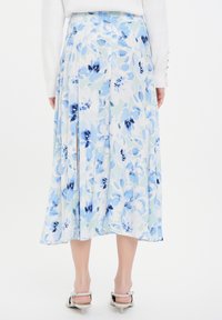 Blumenkleid Midi in Hellblau und Weiß, mit fließendem Design und seitlichem Schlitz; hergestellt aus einem leichten, strukturierten Stoff.