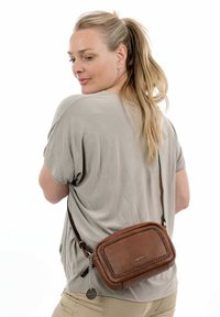 Borsa a tracolla in pelle marrone con dettagli intrecciati, forma rettangolare e hardware a catena removibile. Cinghia regolabile per un indossamento personalizzato.