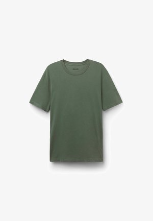 Zelené bavlněné tričko s kulatým výstřihem, krátkými rukávy a volným střihem. Hladká textura s jemnými švy.