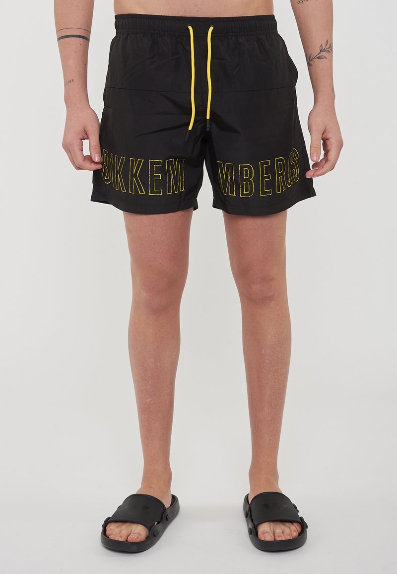 Costumi da bagno neri con cordoncino giallo e la scritta "BIKKEMBERGS" stampata in lettere grandi sulla gamba sinistra. Realizzati in tessuto leggero.