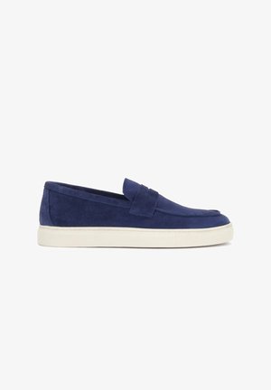 Men’s navy blue suede slip-on loafer with white rubber sole and strap detail on top, shown in side view on a white background.