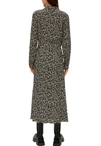 Lang zwart jurkje met een bloemenpatroon in witte en beige tinten. Gemaakt van lichtgewicht stof, met lange mouwen en een aangesnoerde taille.