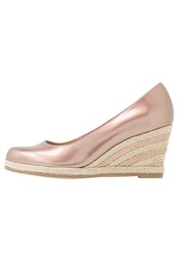 Scarpa wedge color oro rosa con punta arrotondata, finitura lucida e suola in juta intrecciata stile espadrilles. Tacco piatto.