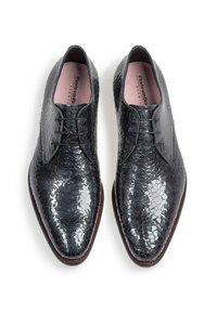 Scarpe nere in pelle con una finitura testurizzata simile a squame, design elegante con punte affusolate e chiusura con lacci.