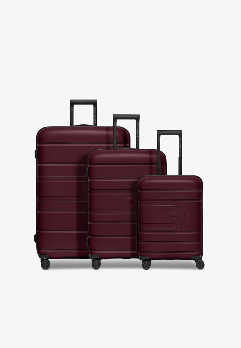 Set di valigie in tre pezzi di colore bordeaux, realizzato in materiale rigido e durevole, caratterizzato da scanalature orizzontali, robuste ruote nere e manici estensibili.
