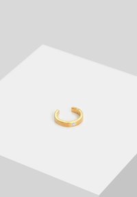 Goldfarbener Metallring mit einem glatten, breiten Band und einem kleinen klaren Edelsteinakzent. Abgerundete offene Enden, minimalistisches Design.