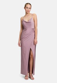 Robe maxi fluide de couleur rose pâle avec décolleté cowl, bretelles spaghetti réglables et fente sur le côté ; fabriquée en tissu léger avec une texture douce.