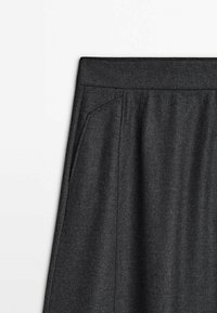 Jupe gris foncé avec une large ceinture et une poche latérale, en tissu texturé semblable à de la laine.