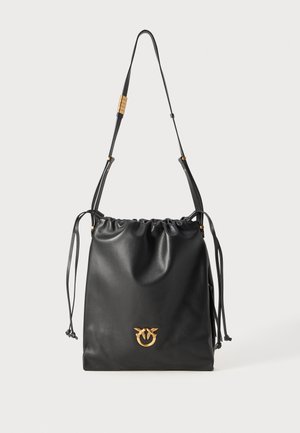 Black leather drawstring bag with a smooth texture, gold hardware accent, adjustable strap, and a front logo detail. Compact and practical design.