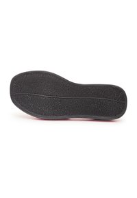 Semelle de chaussure en caoutchouc noir avec une surface texturée, présentant des rainures et un motif pour une meilleure adhérence et durabilité.