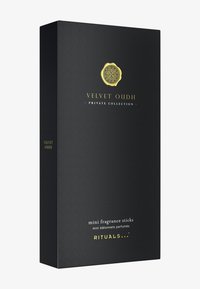 Scatola nera con superficie texturizzata, logo dorato e testo bianco con l'etichetta "mini bastoncini profumati" per Velvet Oudh di Rituals.