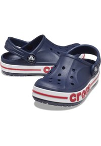 Crocs blu navy con fori di ventilazione, cinturino posteriore regolabile, suola bianca con accenti rossi e logo "Crocs" in evidenza di colore rosso.