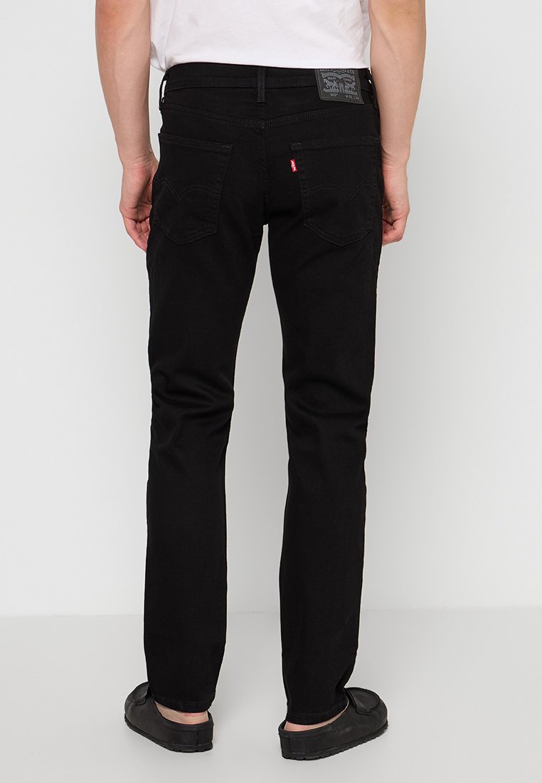 Schwarze Jeans im Slim-Fit, aus Denim gefertigt, mit schlichtem Design, zwei hinteren Taschen mit gebogenen Nähten und einem Markenlabel am Bund.