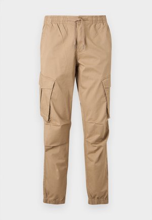 Pantaloni cargo color sabbia con vita elastica, coulisse, tasche laterali con pattina e polsini elastici, mostrati su uno sfondo chiaro.