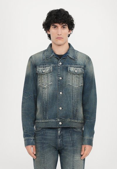 Veste en denim dans des tons de bleu avec une coupe classique, dotée de deux poches poitrine, d'une fermeture à boutons et de détails légèrement délavés.