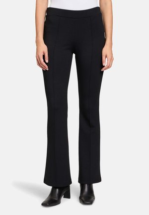 Black flared trousers made from stretch fabric, featuring a smooth waistband and prominent seam details along the front.