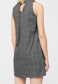 Graues karriertes Kleid mit ärmellosem Design, einem Schlüsselloch-Rückendetail und einer Schleifenakzentuierung am Ausschnitt.