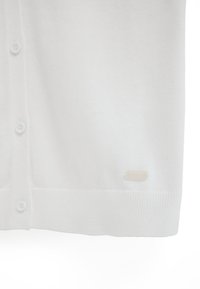 Weißer Strickcardigan mit Knöpfen vorne und einem kleinen "Polo Club" Logoetikett nahe dem unteren Saum auf der rechten Seite.