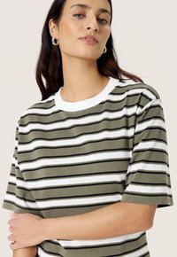 Camiseta a rayas en verde oliva, blanco y negro. Presenta un cuello redondo y mangas cortas, con una textura suave y lisa.