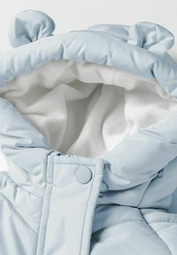 Lichtblauwe pufferjack met een zachte witte binnenkant, ronde oortjes op de capuchon en drukknoopsluiting, met een gewatteerde textuur en een soepele stof.