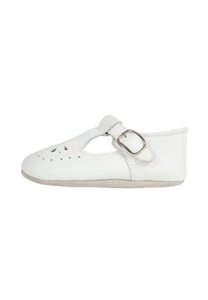 Zapato de bebé de cuero blanco con correa lateral con hebilla y agujeros decorativos perforados en la parte superior, suela blanda, visto de lado.