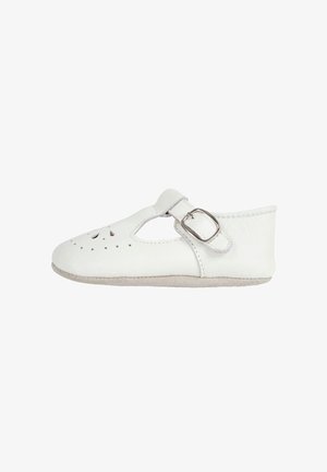 Chaussure bébé en cuir blanc avec bride latérale à boucle et trous décoratifs perforés sur le dessus, semelle souple, vue de côté.